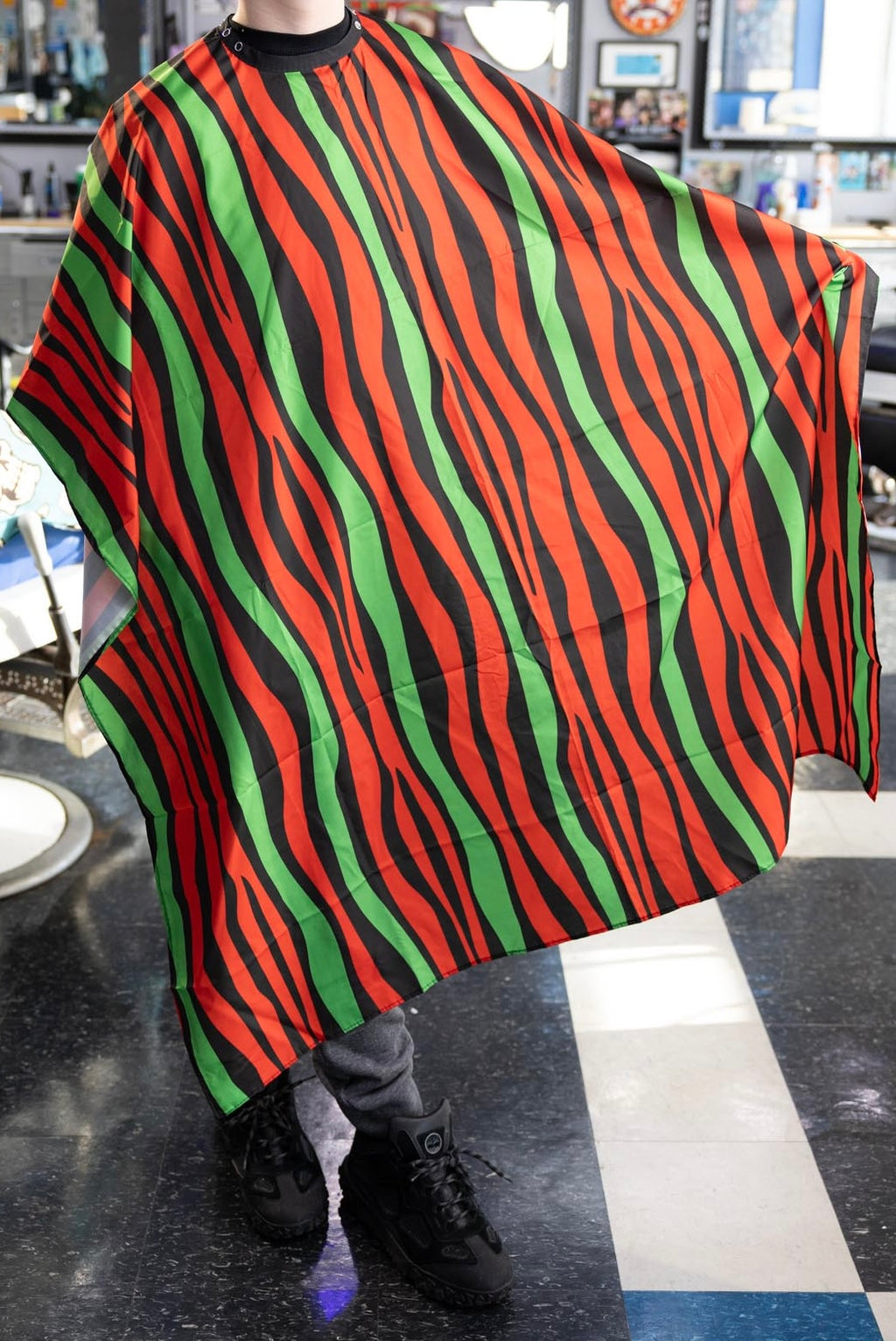 Red Black and Green Striped Themed waterproof professional barber and salon cape with metal snap closures and unique design including the Pan-African style horizontal stripes RBG