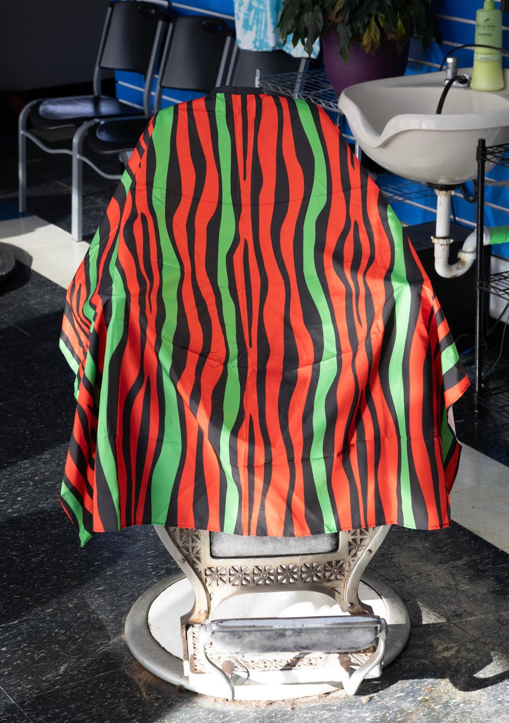 Red Black and Green Striped Themed waterproof professional barber and salon cape with metal snap closures and unique design including the Pan-African style horizontal stripes RBG