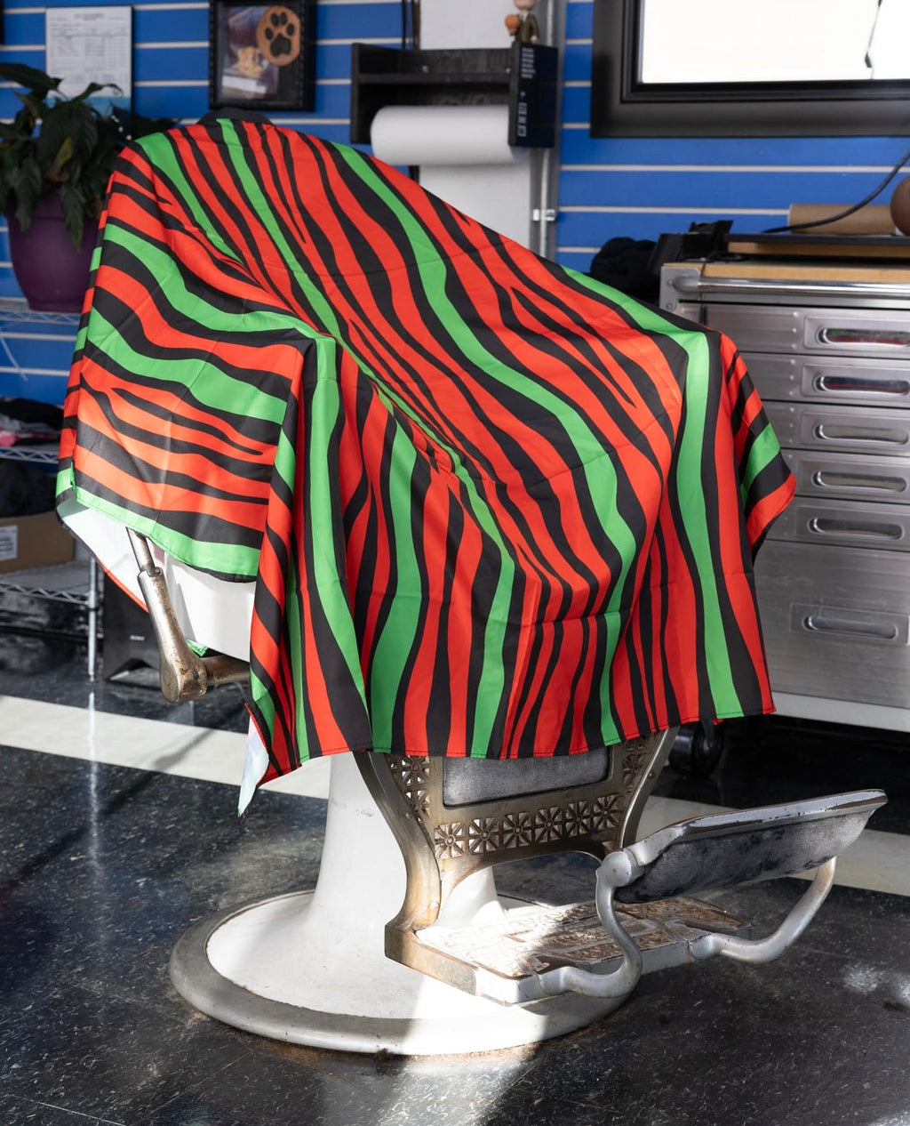 Red Black and Green Striped Themed waterproof professional barber and salon cape with metal snap closures and unique design including the Pan-African style horizontal stripes RBG